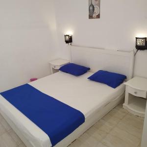 a bedroom with a white bed with blue pillows at bella vita- city center- criss resort in Sharm El Sheikh