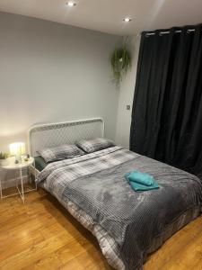 1 dormitorio con 1 cama con cortina negra en Vf apartments kingsbury, en The Hyde 11 fotos más