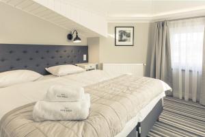 a bedroom with a bed with towels on it at Villa Astra Baltica in Międzyzdroje