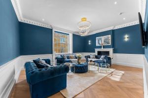 a living room with blue walls and blue couches at Luxury Living in Bath - The Bridgeton - Sleeps 20 in Bath