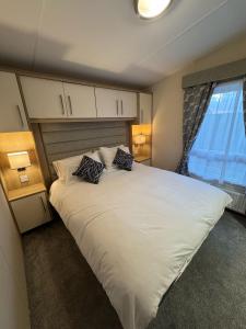 a bedroom with a large white bed with two pillows at Golden Palm Resort - Sequoia Palm - Coastal Caravan Breaks in Chapel Saint Leonards