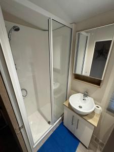 a bathroom with a shower and a sink at Golden Palm Resort - Sequoia Palm - Coastal Caravan Breaks in Chapel Saint Leonards