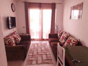 a living room with two couches and a tv at bella vita- city center- criss resort in Sharm El Sheikh