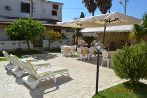 un patio con tavolo, sedie e ombrellone di Mare e Sole Villa Urso ad Avola Altre 28 foto