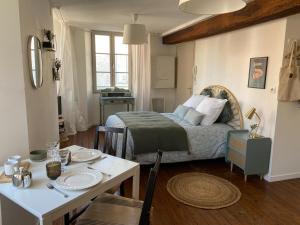 a small room with a bed and a table with a table sidx sidx at La Bohème ô coeur du centre ville in Les Herbiers