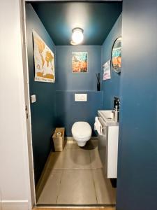 a blue bathroom with a toilet and a sink at Charmant logement avec vue jardin - proche du métro in Asnières-sur-Seine