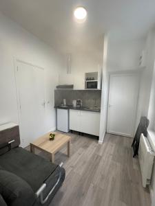 a room with a bed and a table and a kitchen at Lune Argentée - Centre ville Clermont Ferrand in Clermont-Ferrand