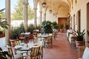 a restaurant with tables and chairs and potted plants at The Hoxton, Florence in Florence