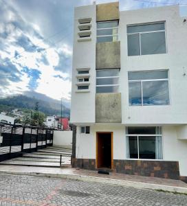 a white building with a door on a street at Casa Amplia in Ambato