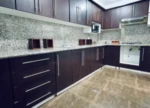 a kitchen with dark wood cabinets and marble counter tops at Casa Amplia in Ambato