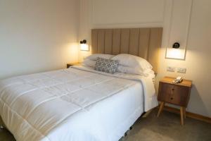 a bedroom with a large white bed and a night stand at Bellavista Bed & Breakfast in Cajamarca