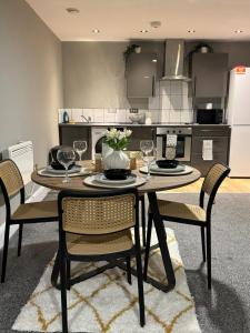 a kitchen with a table and chairs with wine glasses at Ancoats 2BR with Private terrace in Manchester