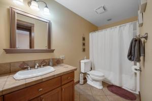 ein Badezimmer mit Waschbecken, Toilette und Spiegel in der Unterkunft Family Getaway 3 Br Walk To Beach Jacuzzi Tub in Rockaway Beach + 26 Fotos