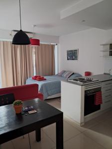 cocina y sala de estar con cama y mesa en Corazón de Villa Crespo, en Buenos Aires