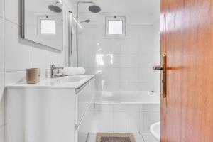 ein weißes Badezimmer mit Waschbecken und Badewanne in der Unterkunft Cozy Seaside Cottage Ocean Views and Near Beach in Caniço + 60 Fotos