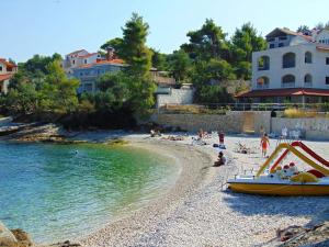 a group of people on a beach with a boat at Apartment Simi in Postira