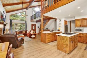 an open kitchen and living room with wooden cabinets at Relaxing Four Bears Cabin in Big Bear Lake in Big Bear Lake