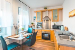 a kitchen with a table and chairs and a sink at Sleeping Home - Red House - Großes Haus für Gruppen mit 2 Wohnungen - 15 Betten - 2 Küchen - Parkplätze - Self Check-in in Bielefeld