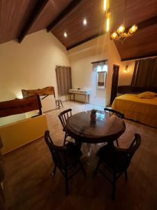 a room with a table and chairs and a bed at Bangalô império verde in Chã Grande