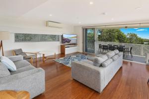 a living room with two couches and a television at Hume Parade 19, Unit 2, Currimundi in Kawana Waters +5 photos