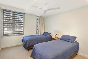 two beds in a room with a window at Hume Parade 19, Unit 2, Currimundi in Kawana Waters