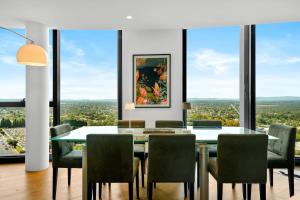 メルボルンにあるIvanhoe Penthouse - Amazing view Masterpiece with parkingのダイニングルーム(テーブル、椅子、大きな窓付)