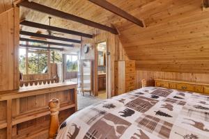 Un dormitorio tipo cabaña de madera con una cama y una ventana. en Mountain Hideaway on Maryland by Big Bear Vacations, en Big Bear Lake