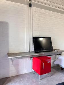 een televisie op een tafel met een rode kast bij Los Origenes Lodge Hotel in Concordia