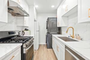 eine Küche mit weißen Schränken und einem Edelstahlkühlschrank in der Unterkunft Modern Cozy Retreat Stylish Stay with Patio & Parking in Monterey Park