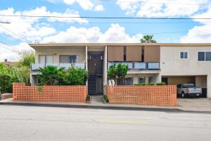 ein Haus mit einem orangenen Steinzaun davor in der Unterkunft Modern Cozy Retreat Stylish Stay with Patio & Parking in Monterey Park