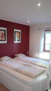 una camera con 2 letti bianchi e una parete rossa di Good Morning Bed and Breakfast a Härslöv