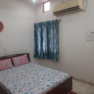 a small bedroom with a bed and a window at Beautiful AC Room, Best Location, Furnished with Kitchen, TV, Fridge, Washing Machine etc at Pachpedinaka Raipur in Raipur