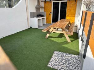 サントマリー・ド・ラメールにあるMaison avec cour 8 personnes - Bazaretteの緑の芝生のあるパティオのピクニックテーブル