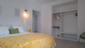 a bedroom with a large bed with a yellow blanket at Suite Deluxe - Villa Luar in Aljezur