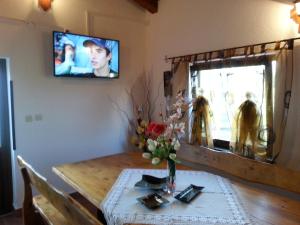 a dining room table with a vase of flowers and a television at Holiday Home Izabela in Kršan