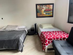 a bedroom with two beds and a couch in it at En Laureles con ascensor , balcón y muy bien ubicado en laureles Medellín , EL BARRIO MAS COOL DEL MUNDO in Medellín