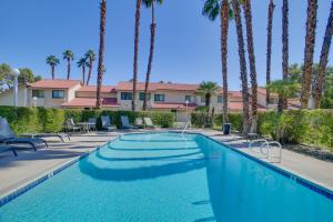a swimming pool with palm trees in a resort at Townhome with Pool Access, Near Dtwn Palm Springs! in Palm Springs