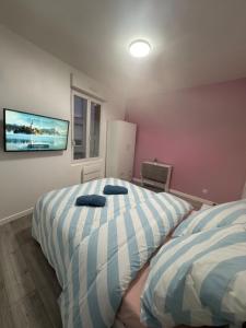 une chambre avec deux lits et une télévision au mur dans l'établissement Soleil Rose, à Clermont-Ferrand