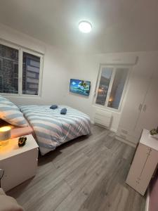 une chambre avec deux lits et deux fenêtres dans l'établissement Soleil Rose, à Clermont-Ferrand