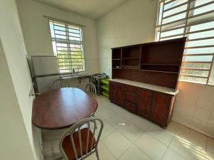 a kitchen with a wooden table and chairs in it at MDRS Seroja 6 in Kuala Ketil
