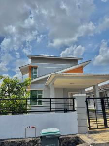 a white house with a fence in front of it at MDRS Seroja 6 in Kuala Ketil