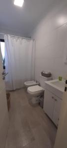 a white bathroom with a toilet and a sink at Hermoso departamento de 2 ambientes in Pilar