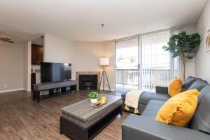 Una sala de estar con un sofá azul y un televisor en Chic Hollywood Retreat 2Bed Rooftop Pool with Iconic Views, en Los Ángeles