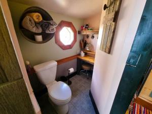 a bathroom with a toilet and a desk and a window at A Charming Mountain Getaway in Historic Como in Como +10 photos
