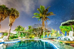 a pool at a resort with palm trees at O'tai in Hanga Roa