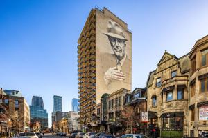 a building with a painting of a man on the side of it at Nice unit in heart of downtown balcony view in Montréal