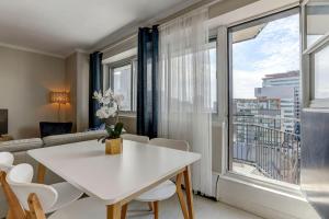 a living room with a white table and chairs and a large window at Amazing 1-bedroom apartment in MTL Downtown in Montréal