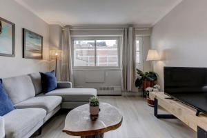 a living room with a couch and a tv at Cozy condo in heart of downtown Montreal in Montréal