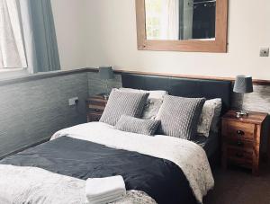 una camera da letto con un letto e uno specchio sul muro di THE LOG CABIN no neighbours sleeps up to 5 people Free parking Bfst drinks PET FRIENDLY a Leicester