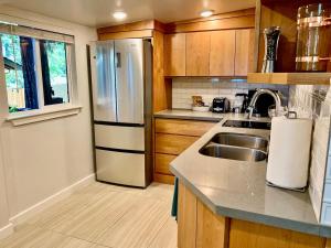 a kitchen with a stainless steel refrigerator and a sink at King Bed-Peaceful Modern Cottage-Garden Setting in Carmichael +13 photos
